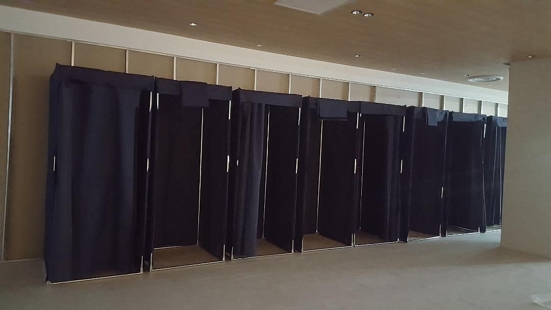 Row of fitting rooms with dark-blue curtains