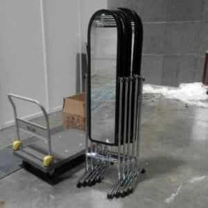 Freestanding full-length mirrors stacked beside a trolley